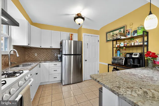 a kitchen with stainless steel appliances granite countertop a sink refrigerator and cabinets