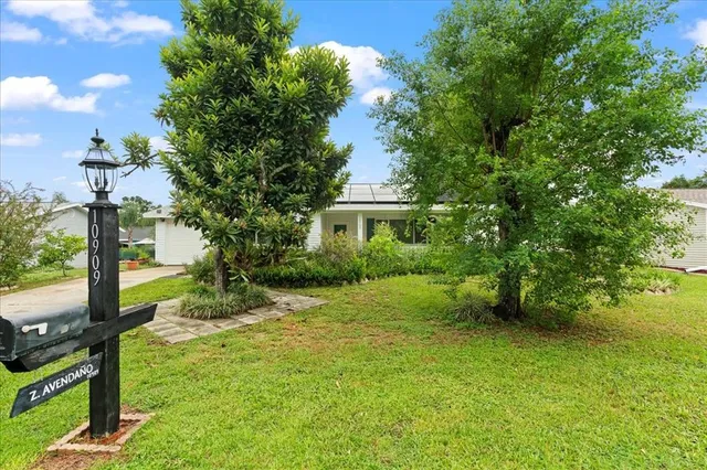 a view of a house with backyard and garden
