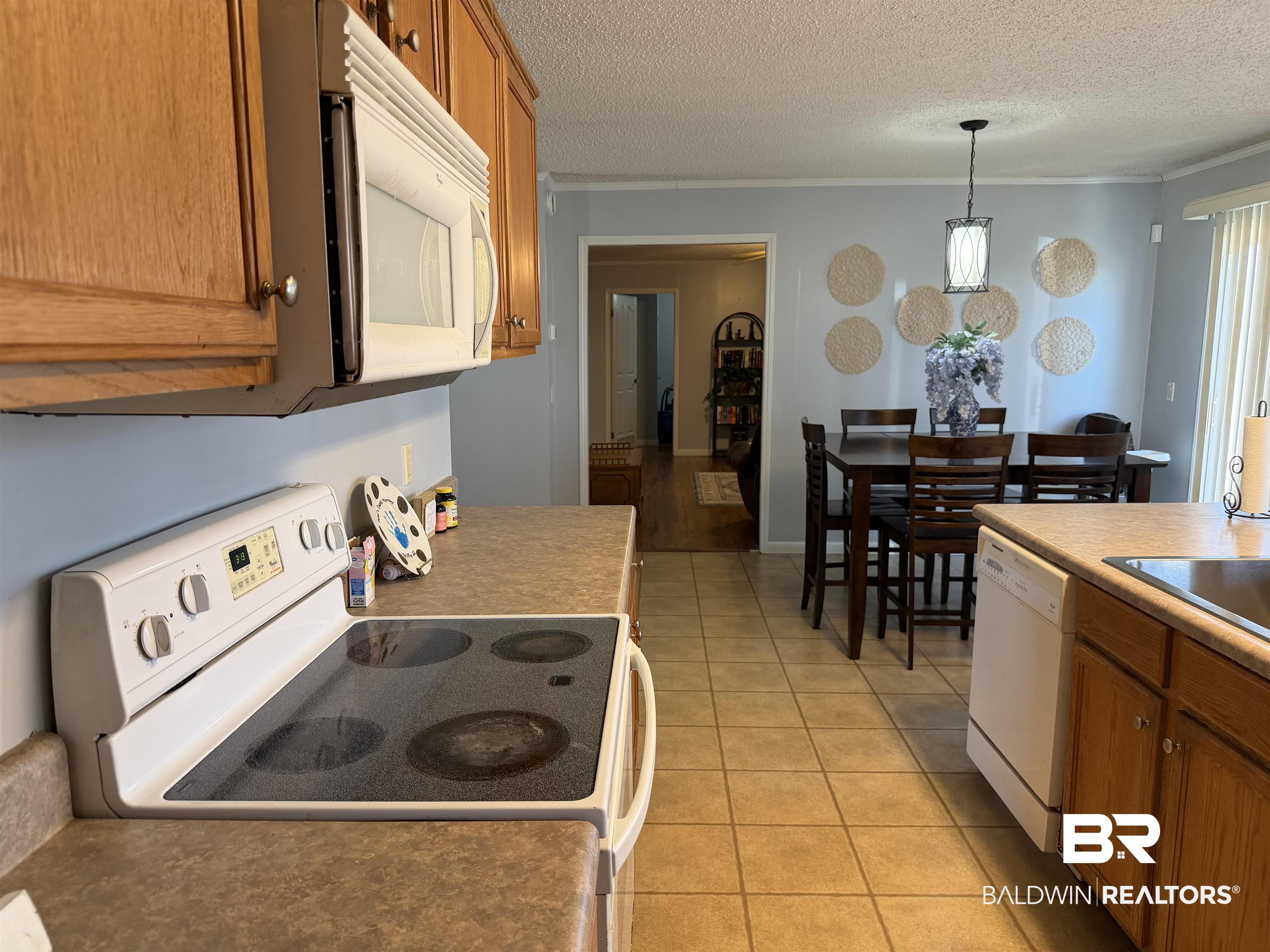 447 Sugar Hill Road Monroeville, AL 36460 - Photo 8 of 27 Kitchen with wood finish cabinetry, white appliances, pendant lighting, a textured ceiling, and ornamental molding