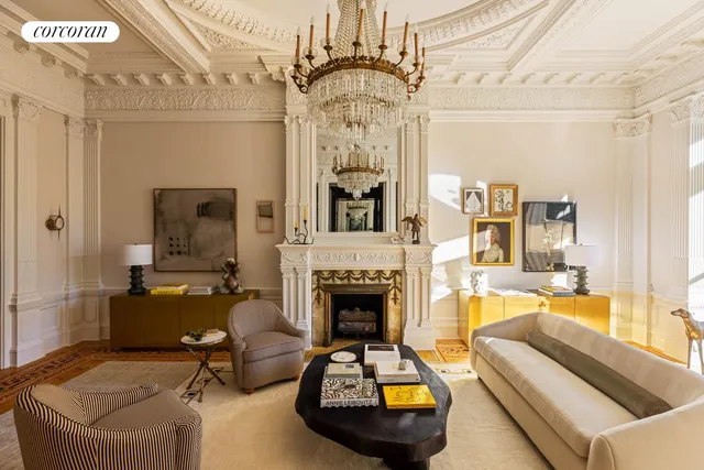 a living room with furniture a fireplace and chandelier