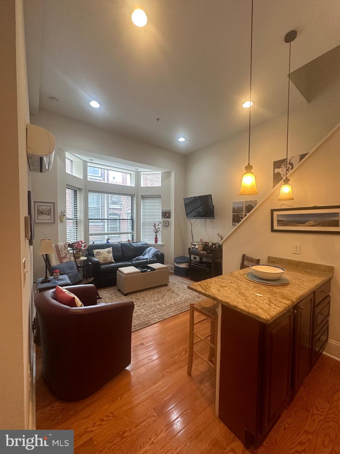 a large living room with stainless steel appliances granite countertop couches a flat screen tv