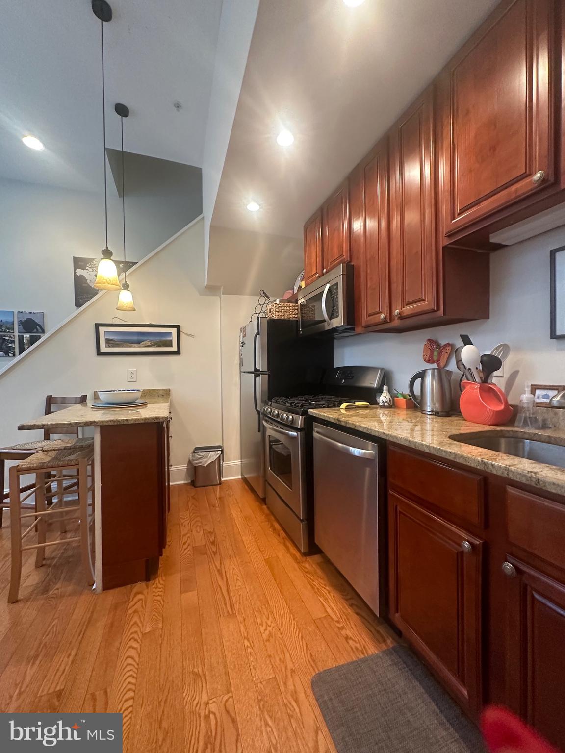 1014 Clinton Street, Unit 2R Philadelphia, PA 19107 - Photo 4 of 16 a kitchen with stainless steel appliances granite countertop a sink a stove and a wooden floors