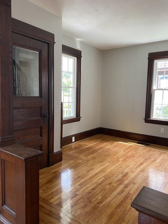 999 Sumner Avenue Springfield, MA 01118 - Photo 11 of 18 an empty room with wooden floor and windows