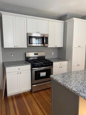999 Sumner Avenue Springfield, MA 01118 - Photo 4 of 18 a kitchen with stainless steel appliances granite countertop a stove a sink and a white refrigerator