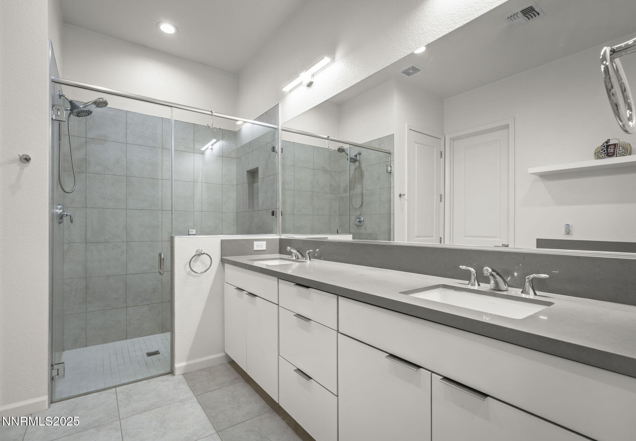 12514 Woods Clover Street Reno, NV 89521 - Photo 5 of 23 a bathroom with a shower sink and mirror