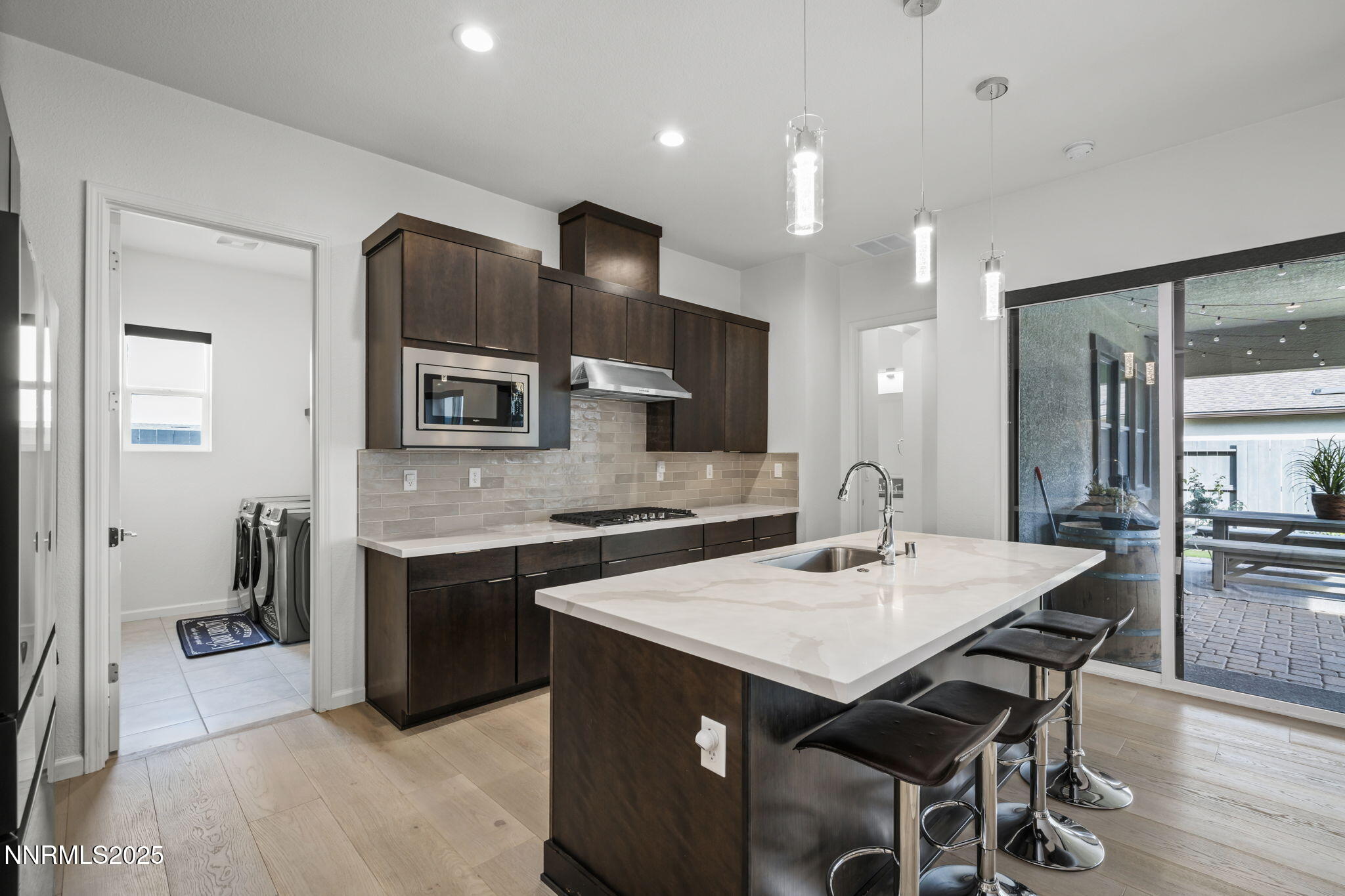 12514 Woods Clover Street Reno, NV 89521 - Photo 10 of 23 a kitchen with a dining table chairs stainless steel appliances and cabinets