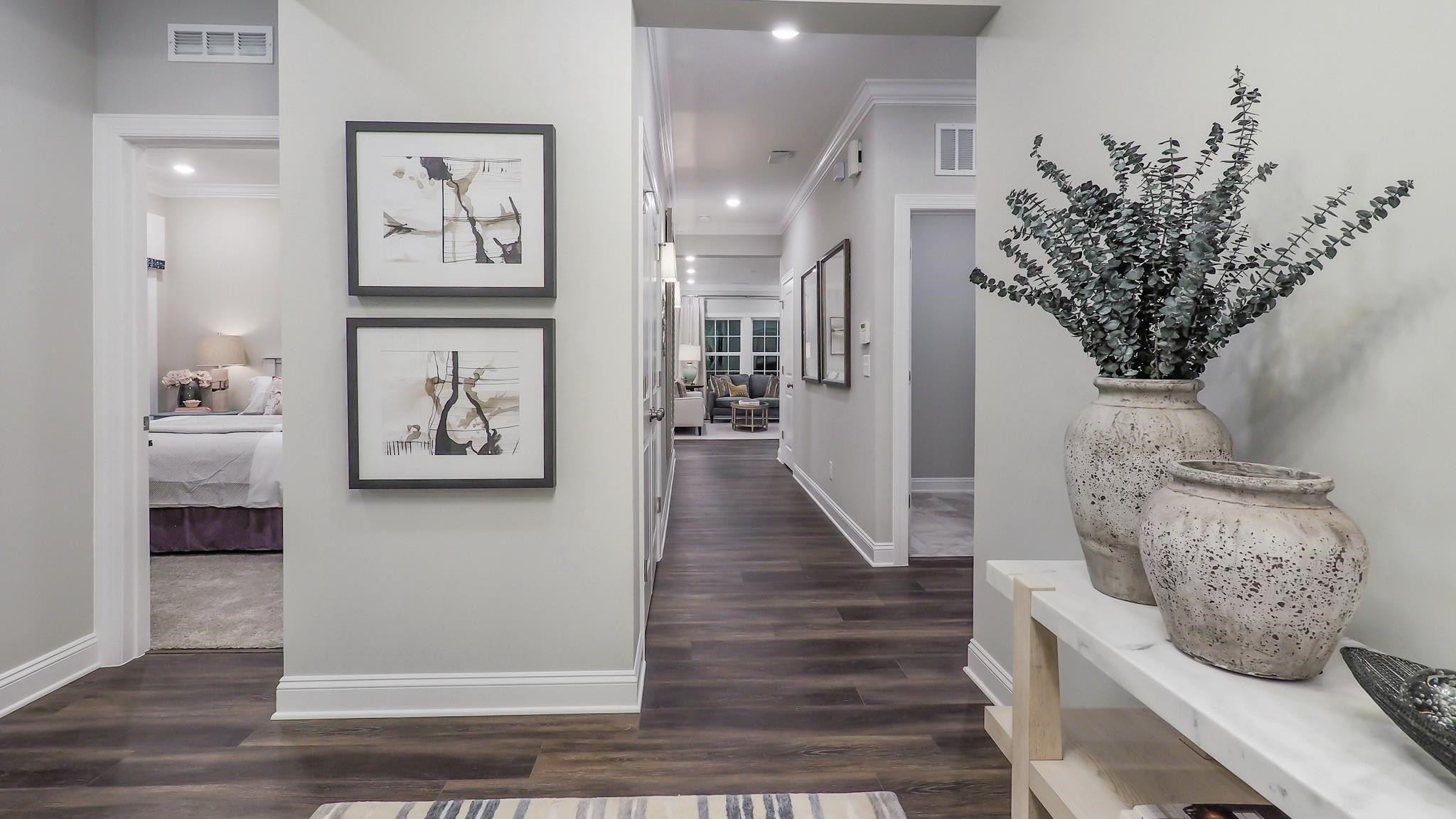 4030 Frontrunner Drive, Unit 46 Durham, NC 27703 - Photo 2 of 25 a view of a hallway with wooden floor and paintings on the wall