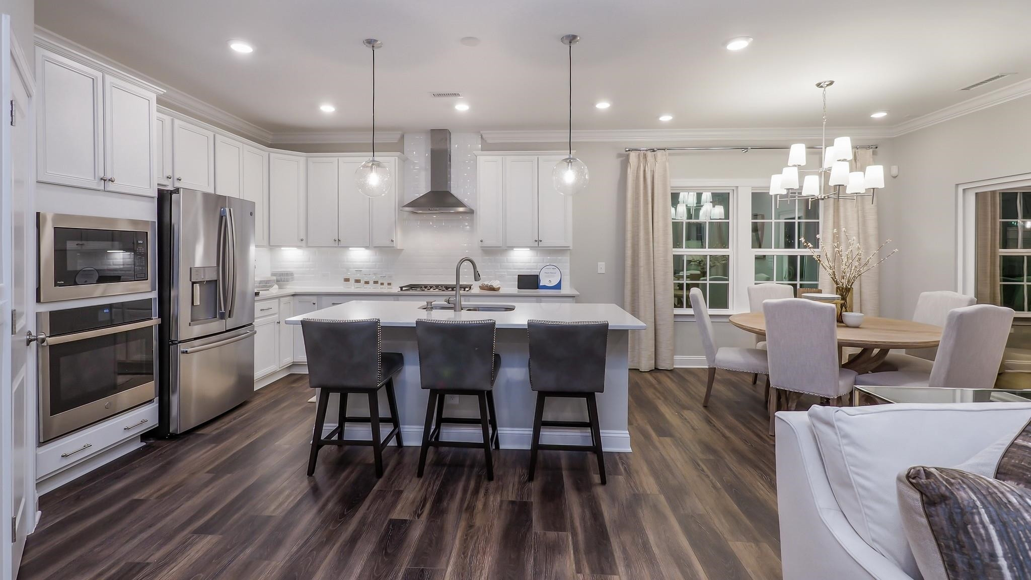 4030 Frontrunner Drive, Unit 46 Durham, NC 27703 - Photo 6 of 25 a kitchen with a dining table chairs and refrigerator