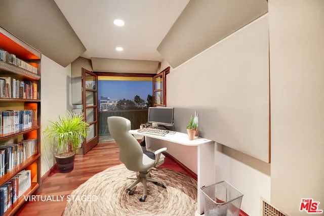 a view of walk in closet with wooden floor and fence