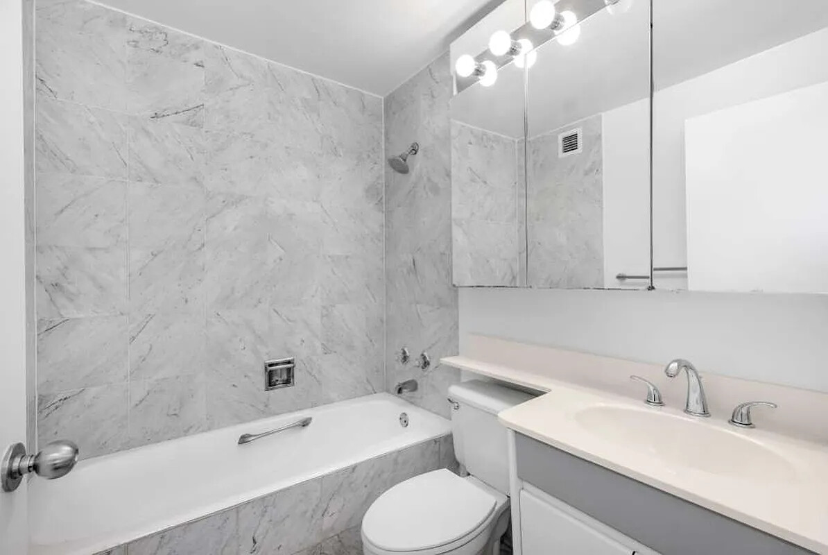 200 Rector Place, Unit 20J Manhattan, NY 10280 - Photo 6 of 13 a bathroom with a sink toilet vanity and bathtub