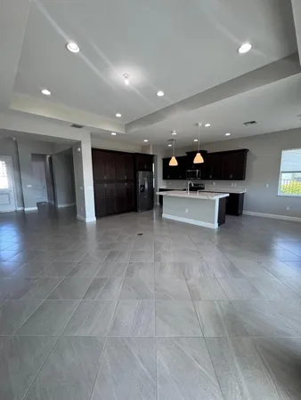 a large kitchen with stainless steel appliances granite countertop a sink a stove and a refrigerator