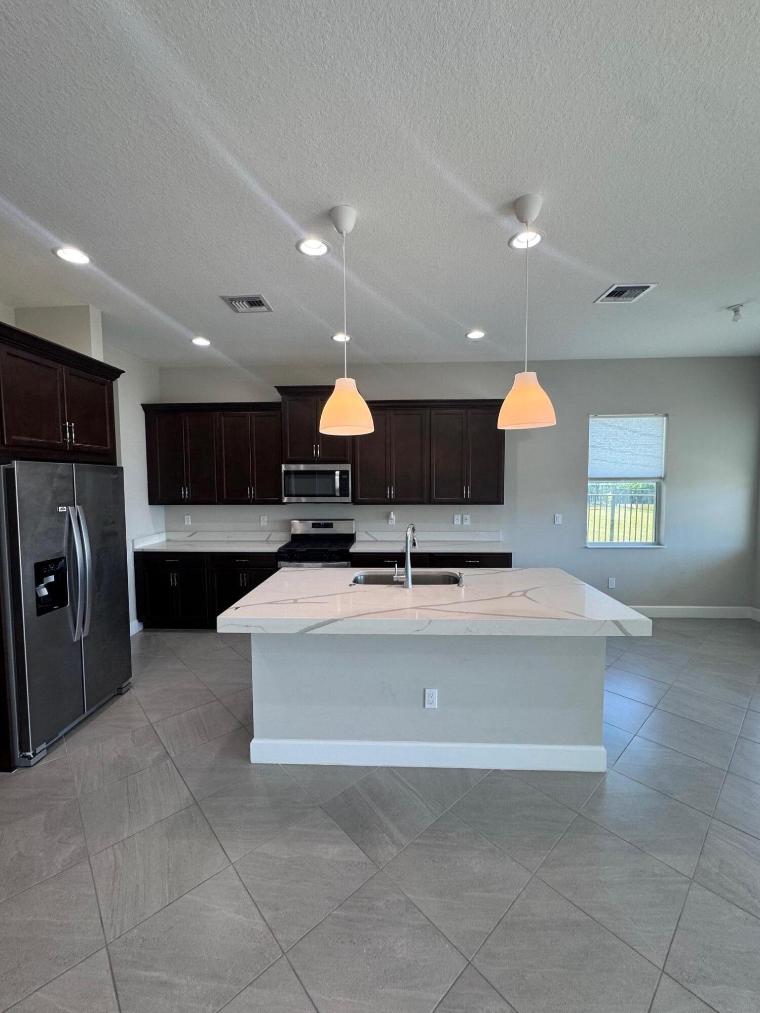 5585 Macoon Way, Unit 5585 Loxahatchee, FL 33470 - Photo 6 of 14 a view of kitchen with stainless steel appliances granite countertop a stove and a sink