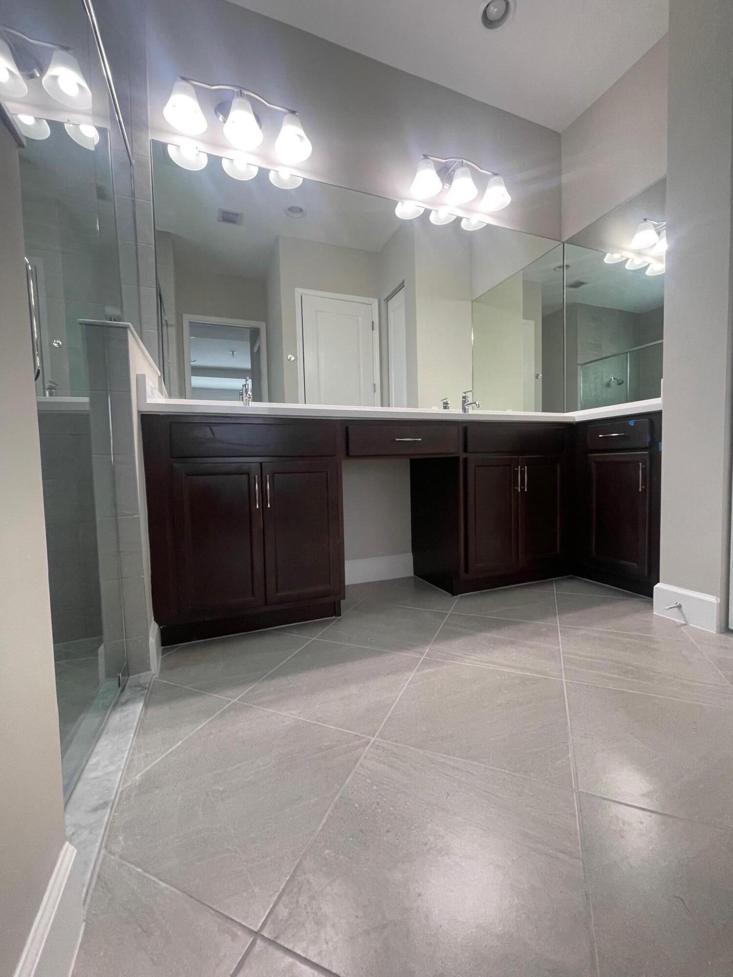 5585 Macoon Way, Unit 5585 Loxahatchee, FL 33470 - Photo 8 of 14 a bathroom with a sink and a large mirror