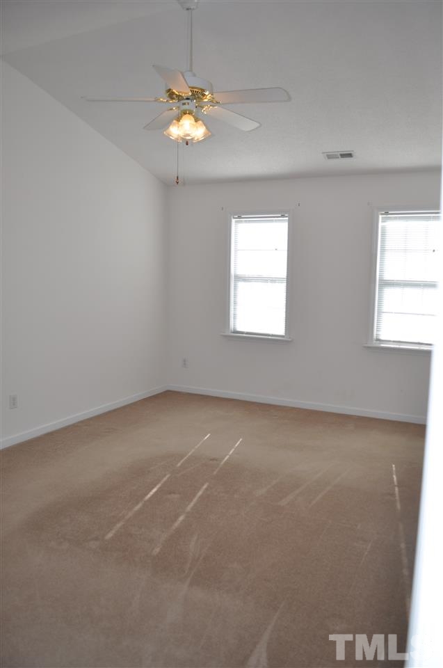 1113 Holland Ridge Drive Raleigh, NC 27603 - Photo 12 of 24 an empty room with windows and chandelier fan