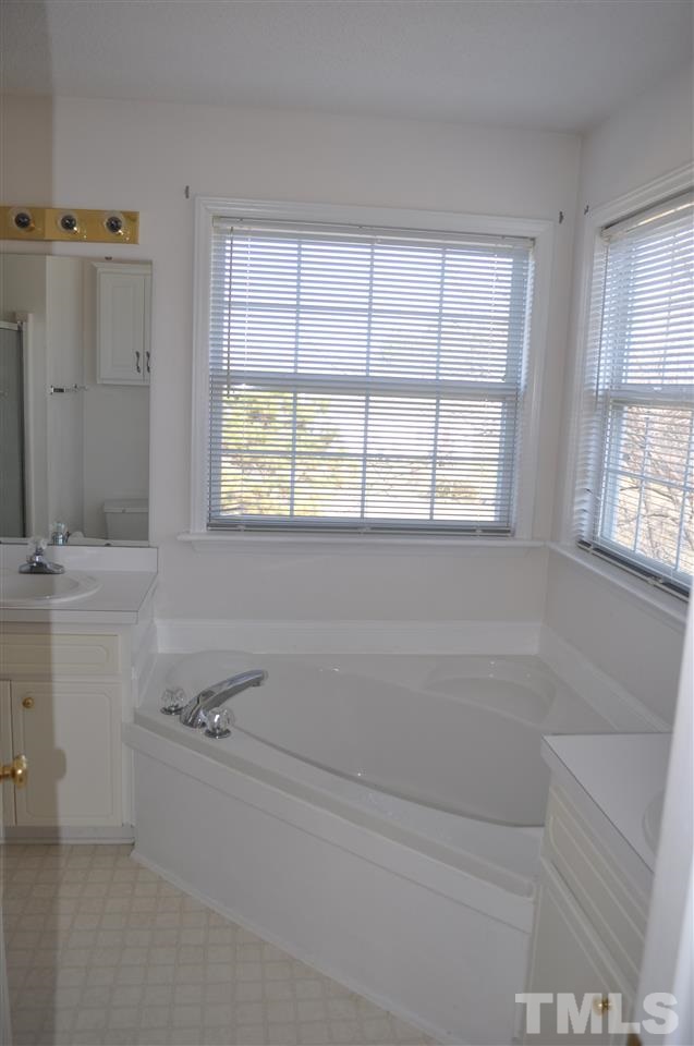 1113 Holland Ridge Drive Raleigh, NC 27603 - Photo 13 of 24 a bathroom with a tub sink and mirror