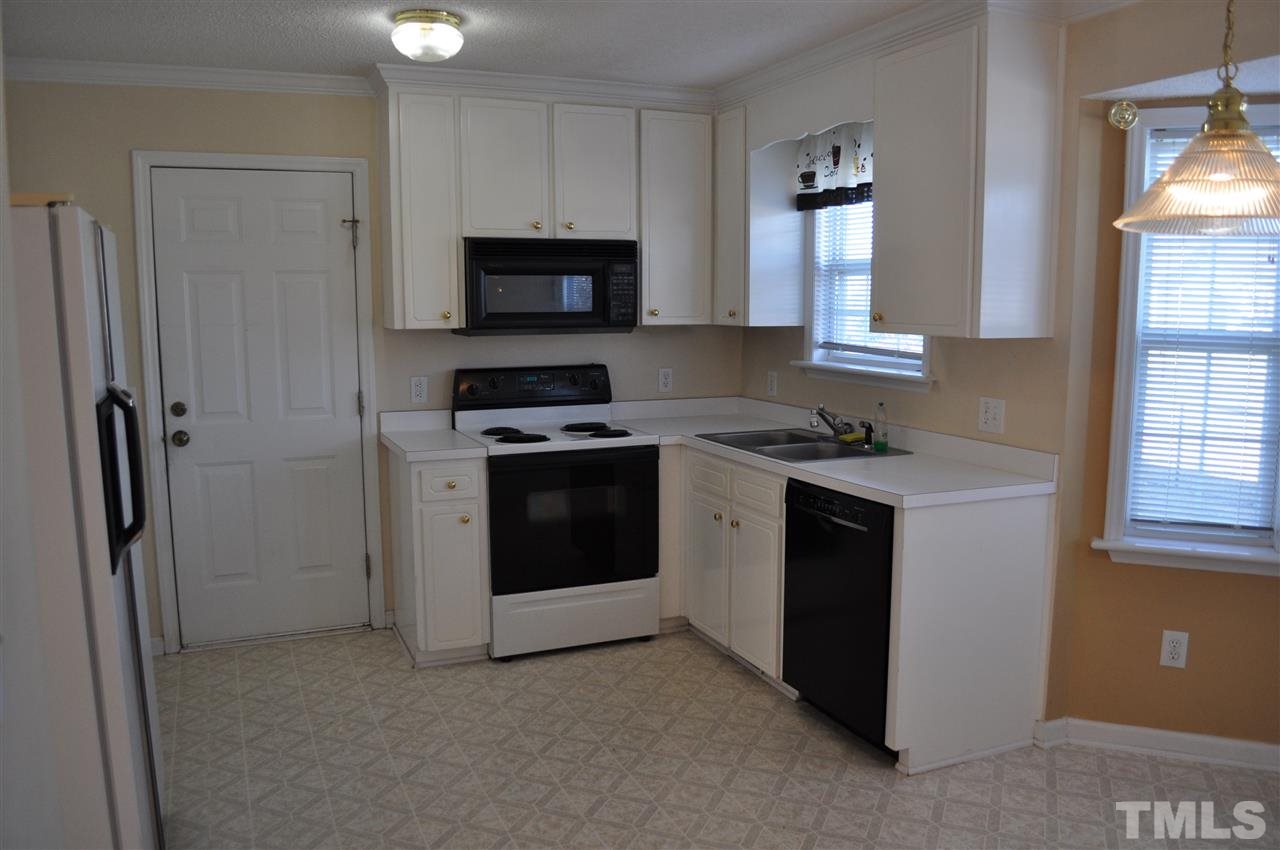 1113 Holland Ridge Drive Raleigh, NC 27603 - Photo 8 of 24 a kitchen with white cabinets and white appliances