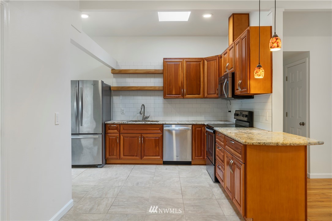 15612 Renton Issaquah Road Southeast Renton, WA 98059 - Photo 5 of 30 a kitchen with stainless steel appliances granite countertop a sink a stove a refrigerator a washer dryer and a refrigerator