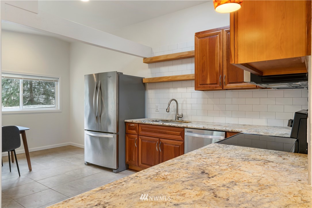 15612 Renton Issaquah Road Southeast Renton, WA 98059 - Photo 9 of 30 a kitchen with stainless steel appliances kitchen island a refrigerator sink and cabinets
