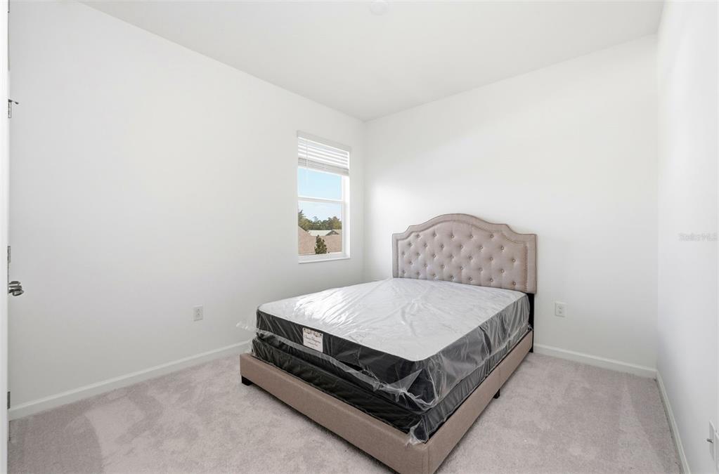 4483 Monado Drive Kissimmee, FL 34746 - Photo 33 of 43 a bed sitting in a bedroom next to a window