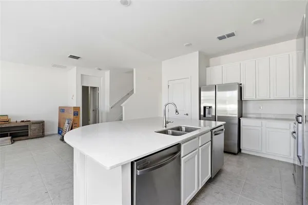 a kitchen with stainless steel appliances a sink a stove a refrigerator and cabinets