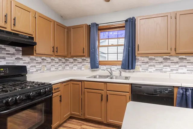 a kitchen with granite countertop a sink stove and cabinets