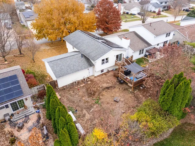 an aerial view of a house with a yard and mountain view in back