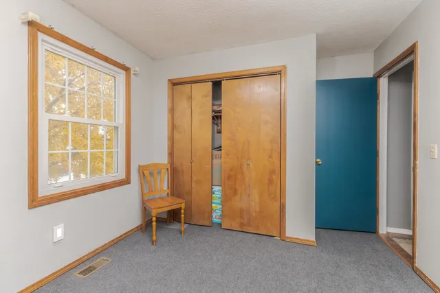 an empty room with windows and closet