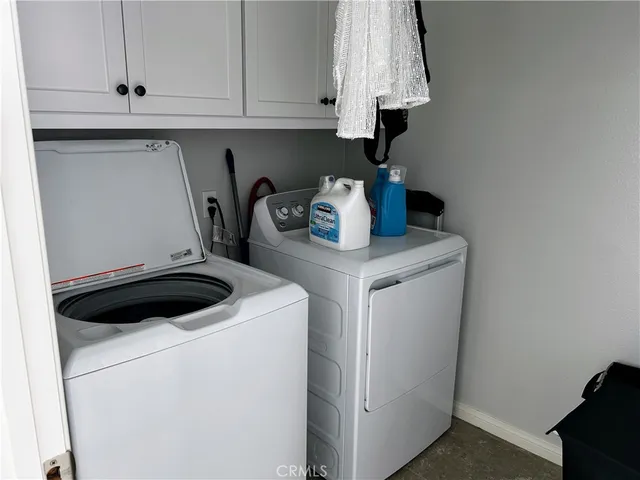 a kitchen with white cabinets and wooden floor