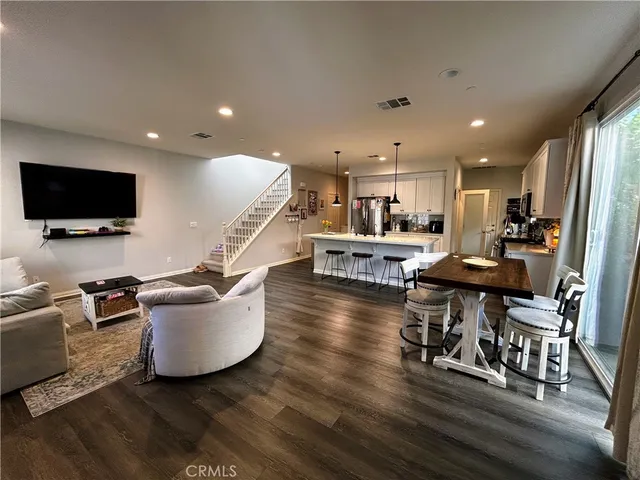 a living room with dining room and wooden floor