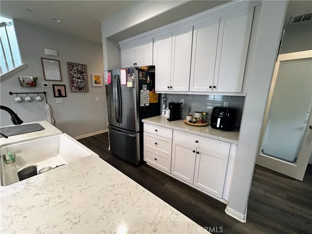 a kitchen with sink a refrigerator and cabinets