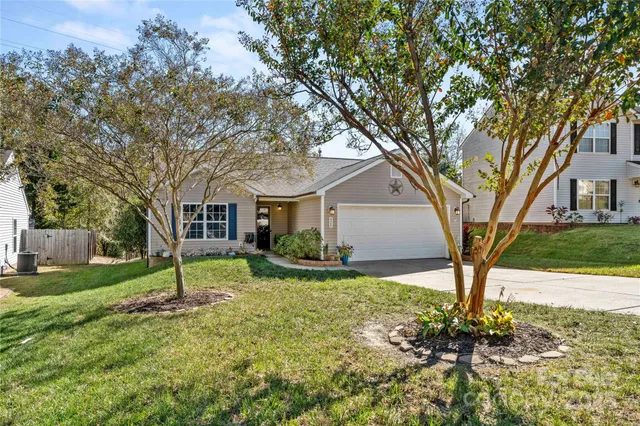 a view of a house with backyard and trees