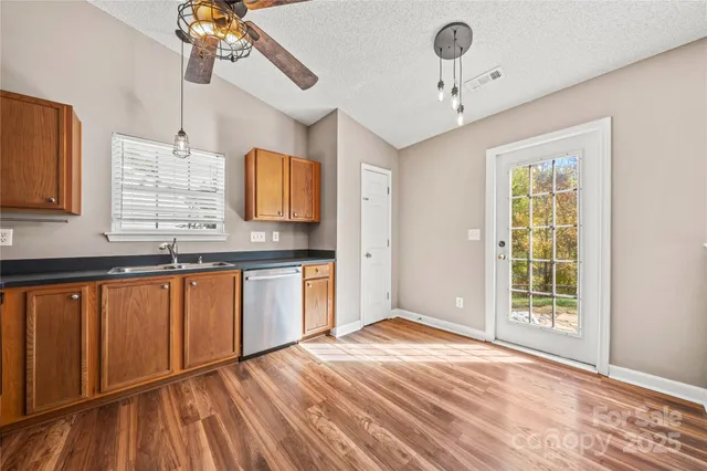 a view of a kitchen with kitchen island a sink wooden floor and a window