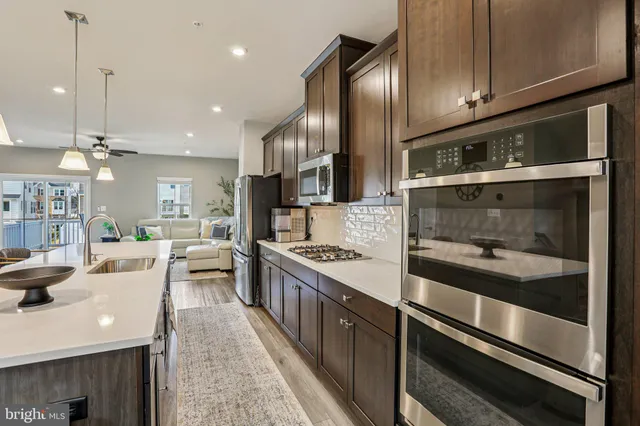 a kitchen with stainless steel appliances kitchen island granite countertop a stove a sink and a refrigerator