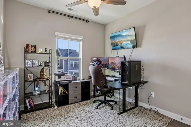 a view of a workspace with furniture and a window