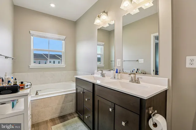 a bathroom with a tub a sink and mirror