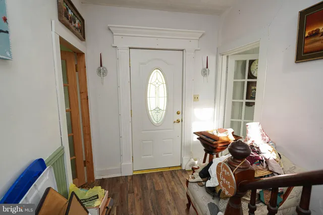 a view of a room with wooden floor mirror and windows
