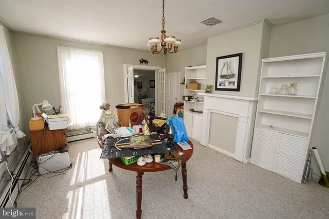a living room with furniture a chandelier and a dining table