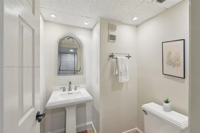 a bathroom with a sink mirror and toilet