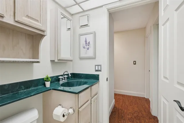 a bathroom with a granite countertop sink a toilet and shower