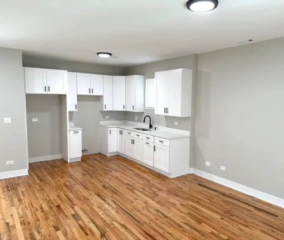 a kitchen with a sink cabinets stainless steel appliances and a window