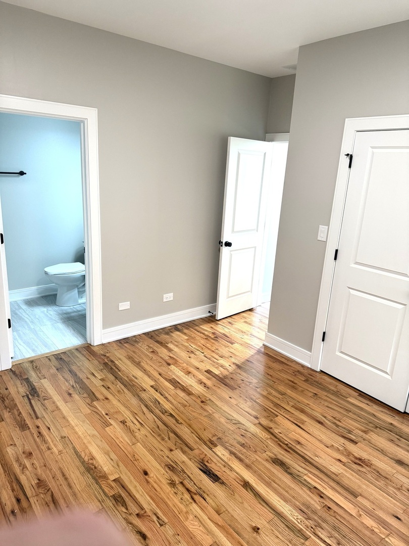 1440 South Kedvale Avenue Chicago, IL 60623 - Photo 9 of 10 a bedroom with wooden floor and toilet