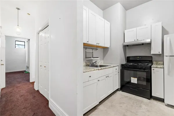 a kitchen with stainless steel appliances a stove refrigerator and cabinets