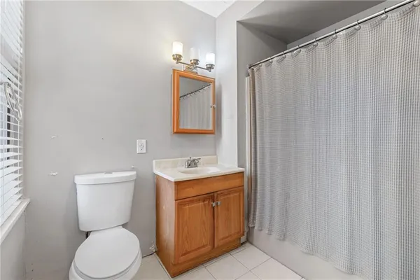 a bathroom with a toilet a sink and curtain