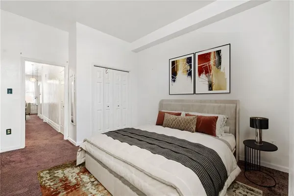 a bedroom with a bed and a painting on the wall