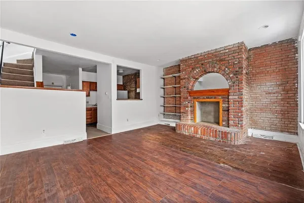 a view of empty room with wooden floor and fireplace
