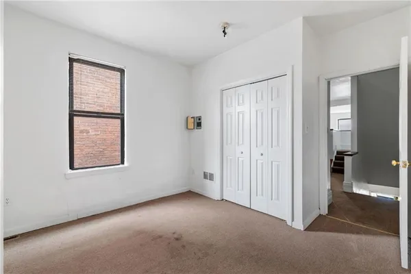 an empty room with windows and closet