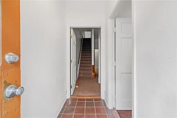 a view of a hallway with wooden floor and a door