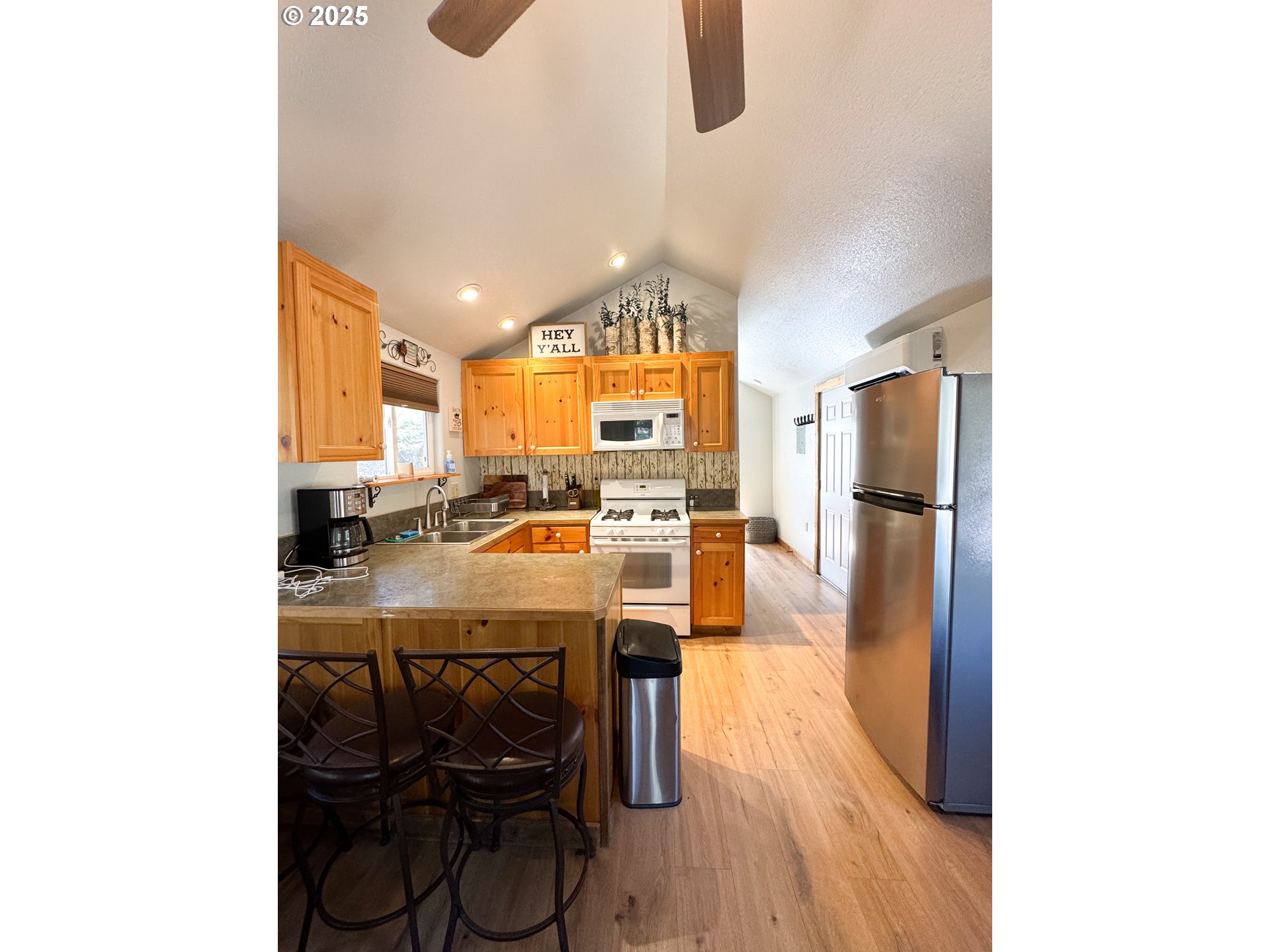 255 East North Street Sumpter, OR 97877 - Photo 4 of 20 a kitchen with stainless steel appliances kitchen island granite countertop a refrigerator a stove a sink with island chairs and wooden floor