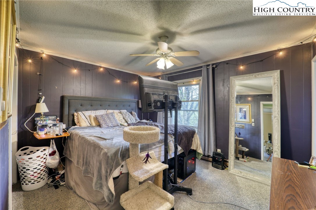 191 Alex Wellborn Road Deep Gap, NC 28618 - Photo 14 of 39 a bed room with bed and a chandelier