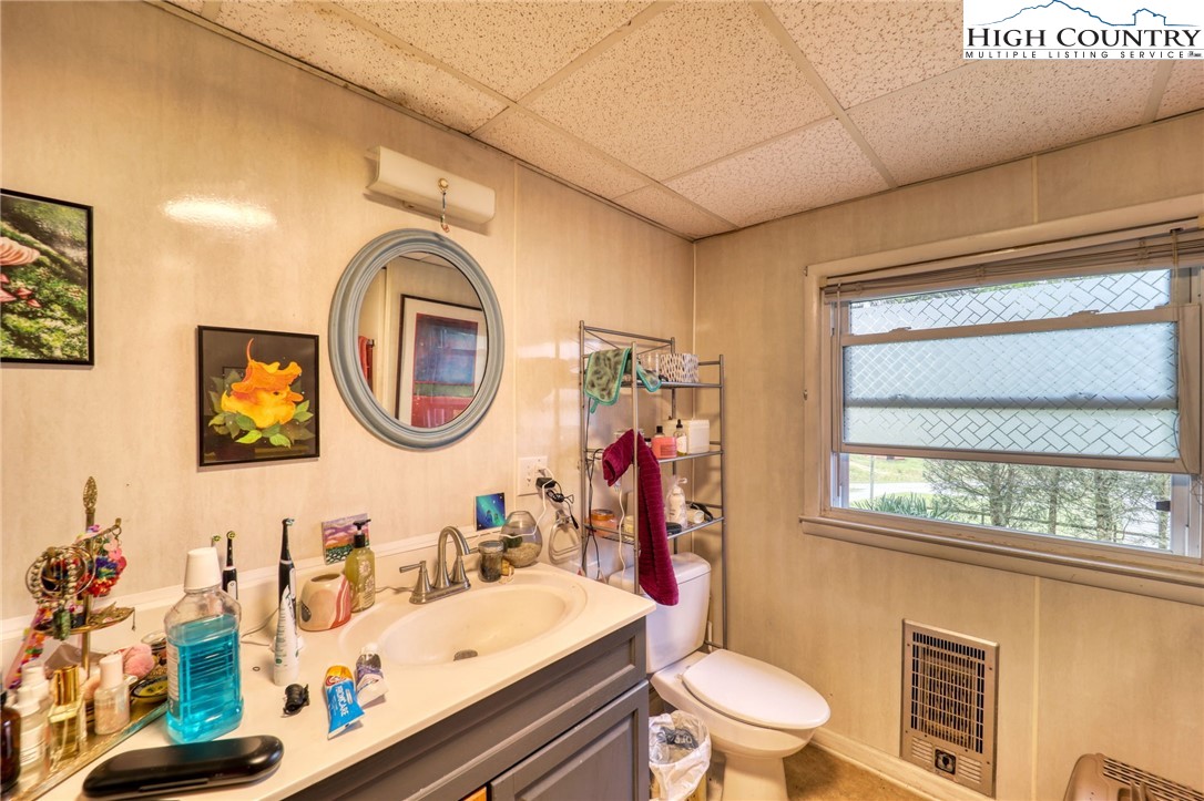 191 Alex Wellborn Road Deep Gap, NC 28618 - Photo 27 of 39 a bathroom with a toilet a sink and a mirror